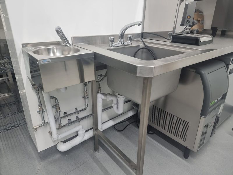 Twin stainless steel sinks with sensor tap and mixer tap installation — Smith EcoFlow commercial kitchen plumbing for hotel restaurant